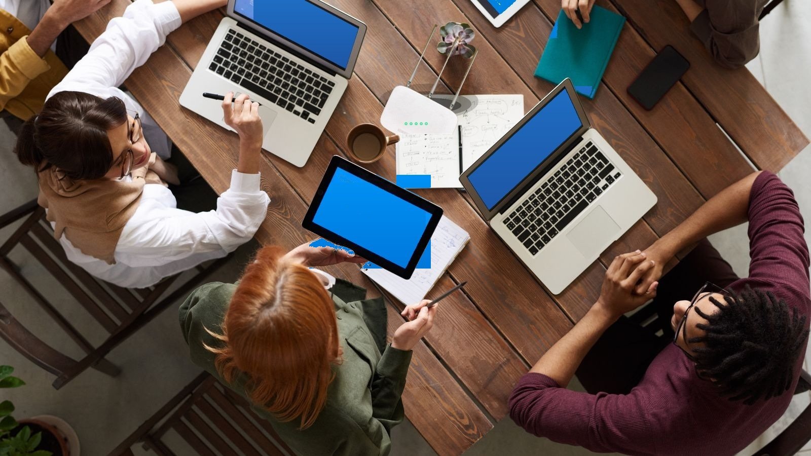 Studierende in einer Wohngemeinschaft am Tisch mit Laptop, Tablet und modernem WLAN-Router