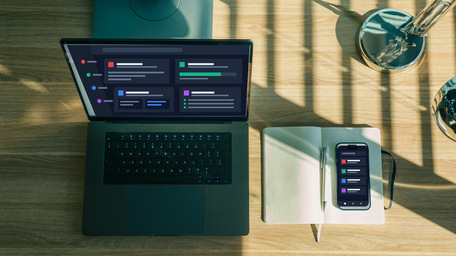 Schreibtisch mit Laptop und Smartphone mit neutralen digitalen Werkzeugen, Notizbuch und Lampe